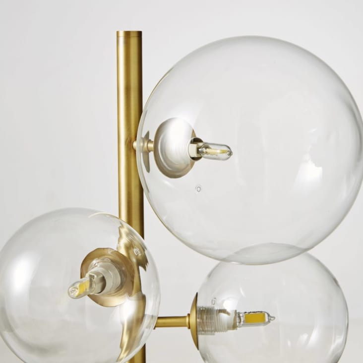 Ein paar kleine runde, kugelförmige led-lampen auf einem goldfarbenen  metallrahmen im innenraum