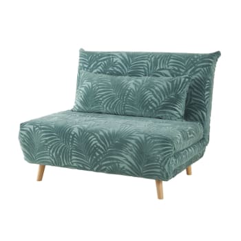 Sillón cama de terciopelo verde con motivos decorativos de palmeras
