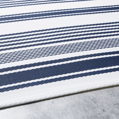 Alfombra de exterior color crudo con motivos decorativos de rayas