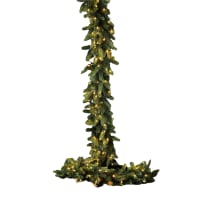 Decorazione di Natale in viola e oro con piume di pavone, luci e palle in un albero di natale Foto stock