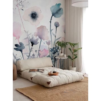 Papier peint fleurs effet aquarelle dans un salon avec canapé beige deplié et plantes vertes pour une ambiance nature