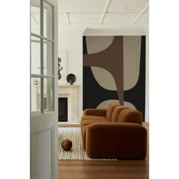 Papier peint aux formes geometriques noir et marron avec un canapé marron et tapis beige