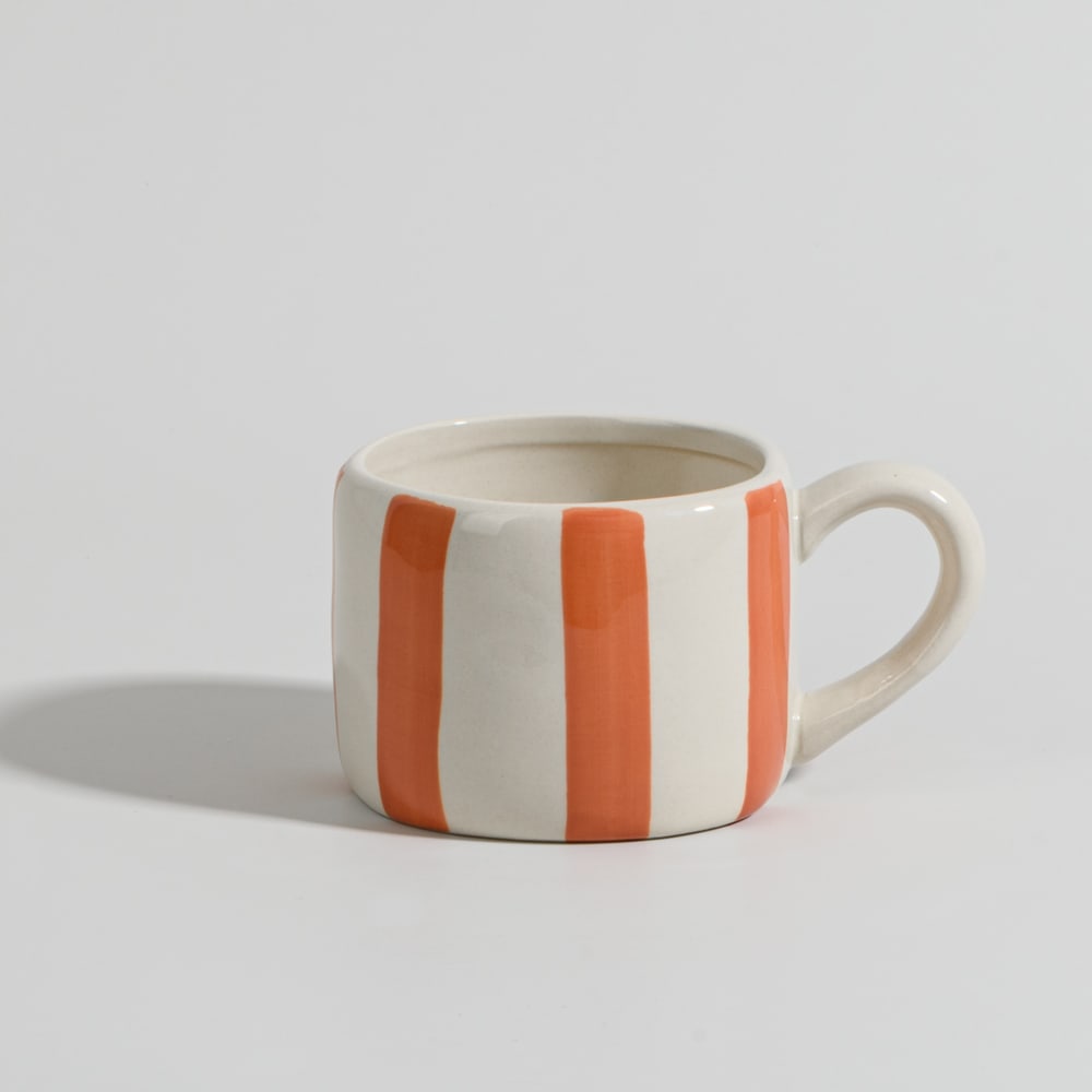 Taza de cerámica blanca y naranja