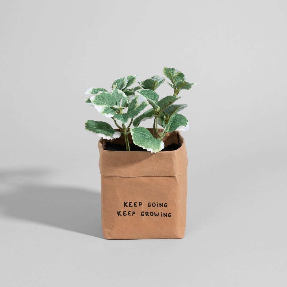 planta artificial en maceta de papel marron