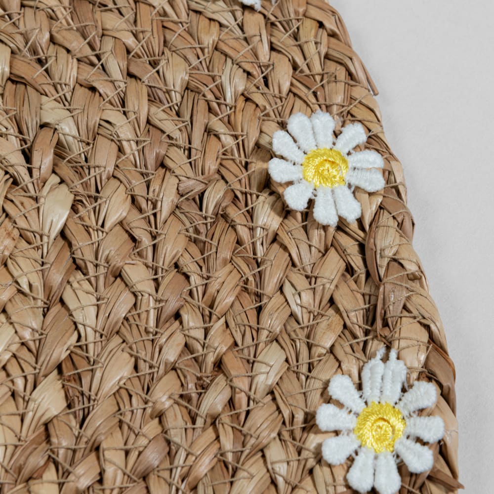 Platzset aus beigefarbenem Seegras mit weißen und gelben Blüten,