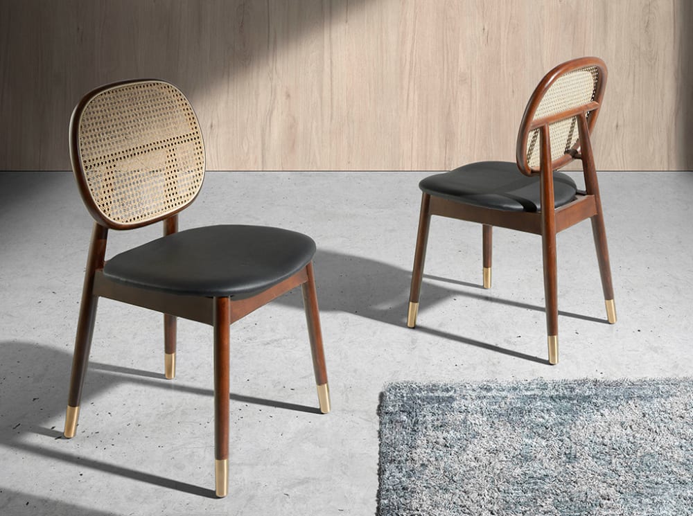 Sedia rivestita in similpelle con schienale in rattan e gambe in