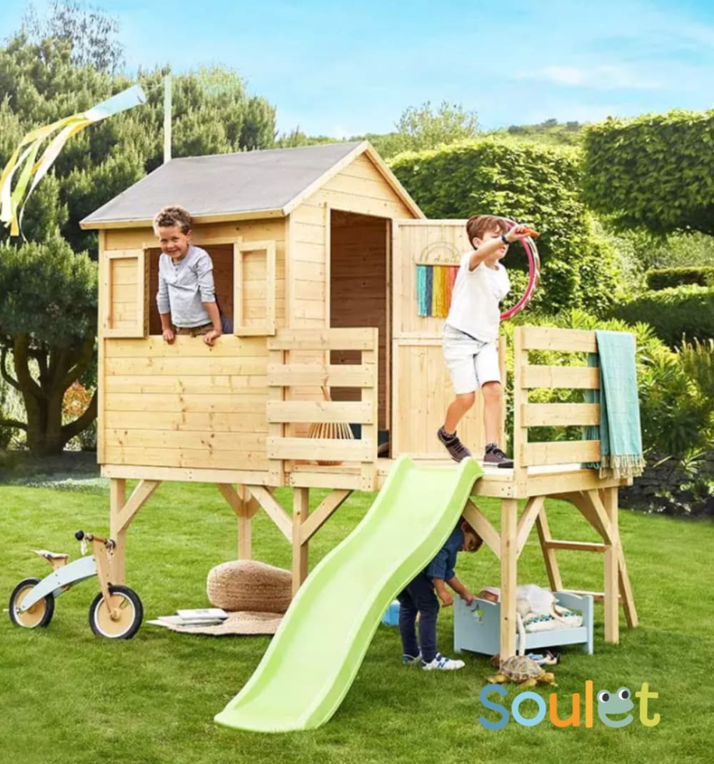 Cabane en bois sur pilotis avec toboggan pour enfants