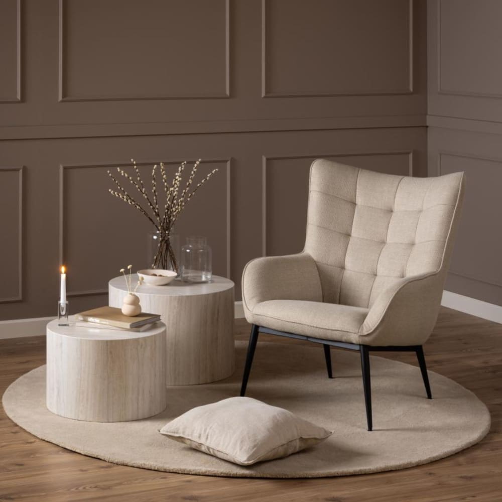 Fauteuil en tissu beige capitonné piétement oblique en métal noir