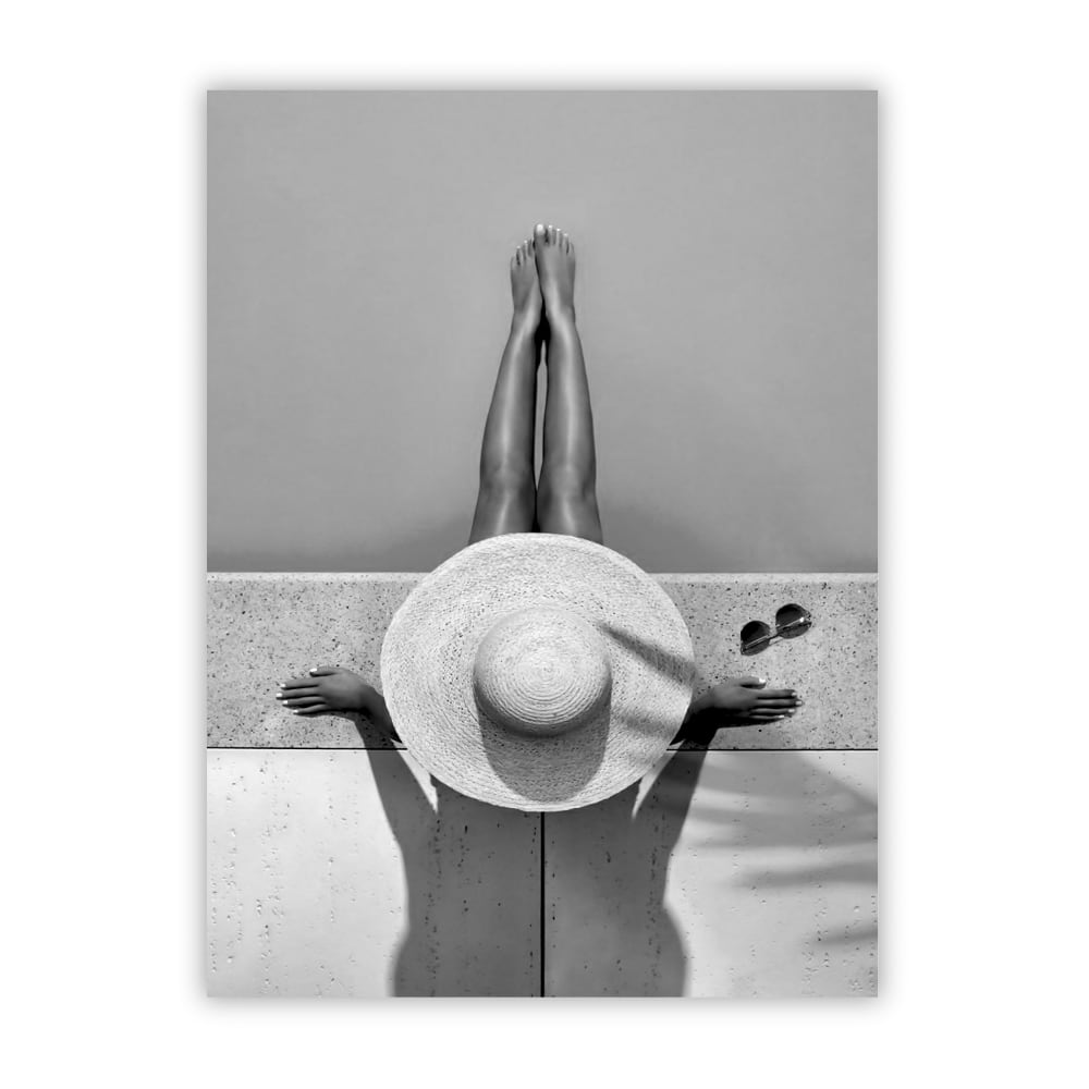 POSTER LAB Schwarz-Weiß-Fotografie einer minimalistischen Schwarz-Weiß-Komposition, die gebräunte Beine und einen breiten Strohhut im Sonnenlicht