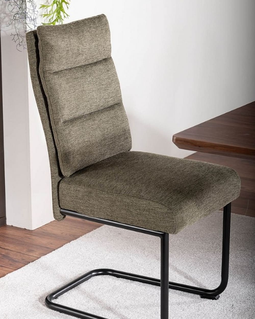 Designerstuhl aus olivgrünem Stoff mit schwarzem Metallgestell -